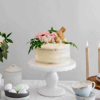 Lemon Easter Cake on a white cake platter next to candles for Easter Cake round up
