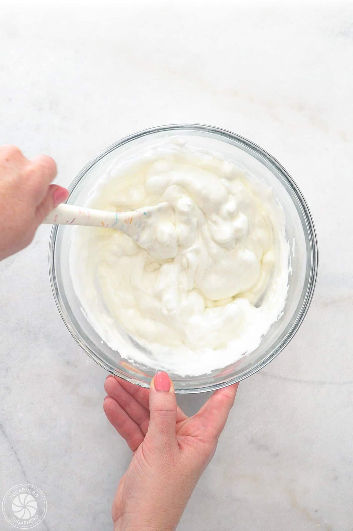 Hand stirring heated marshmallows.