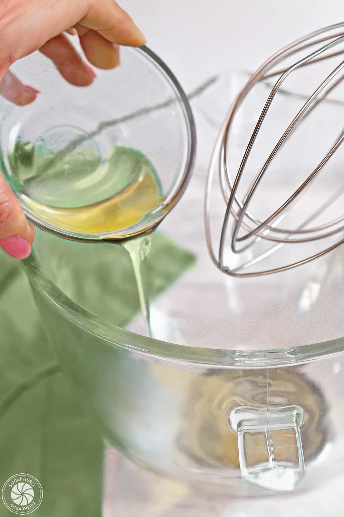 Pouring egg whites into a mixing bowl.