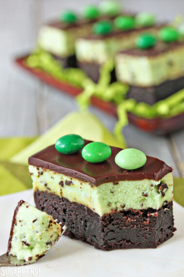 A Mint Chocolate Chip Mousse Brownies on a white plate with a fork holding a bite.