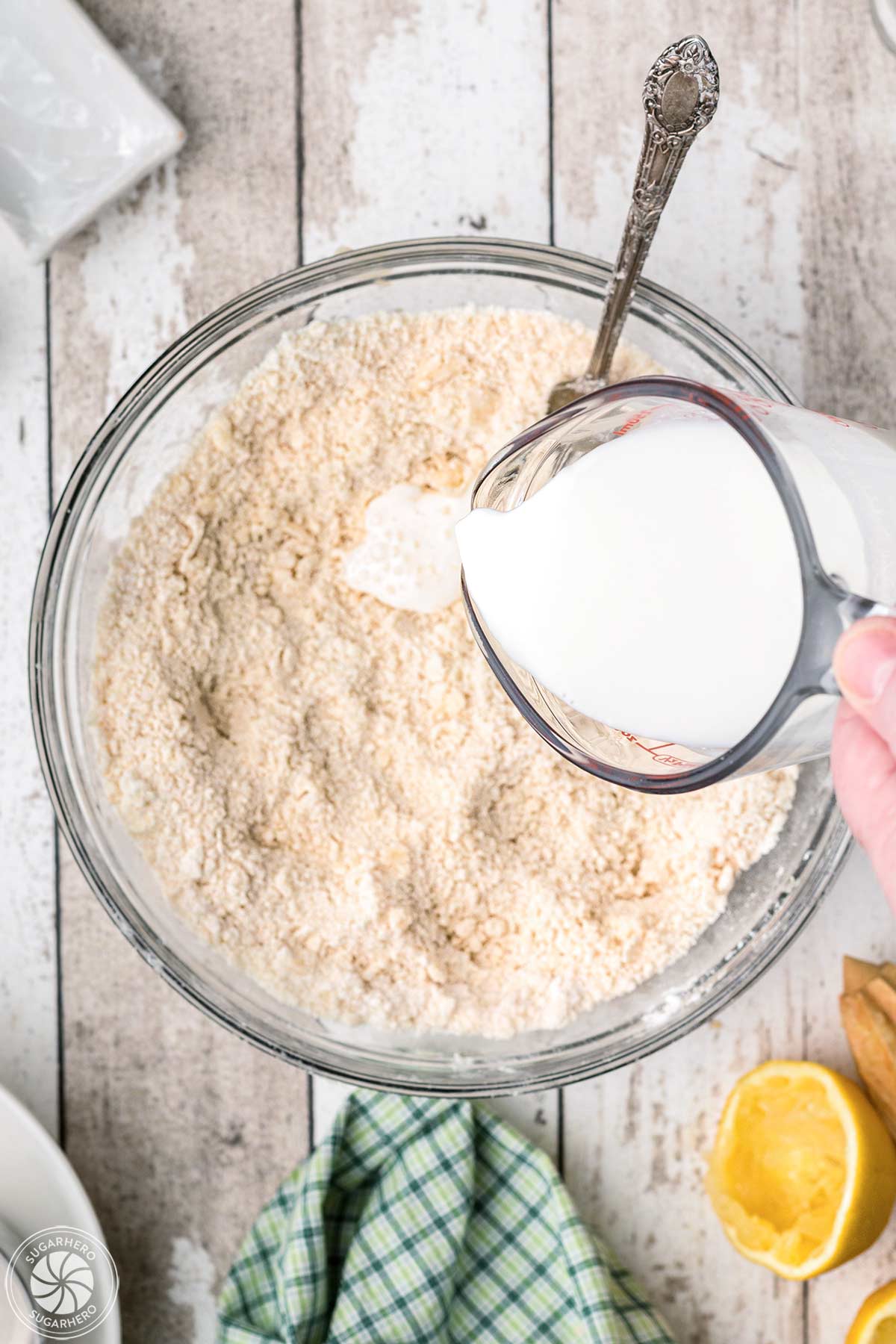 Buttermilk being poured into the batter for the cobbler topping.