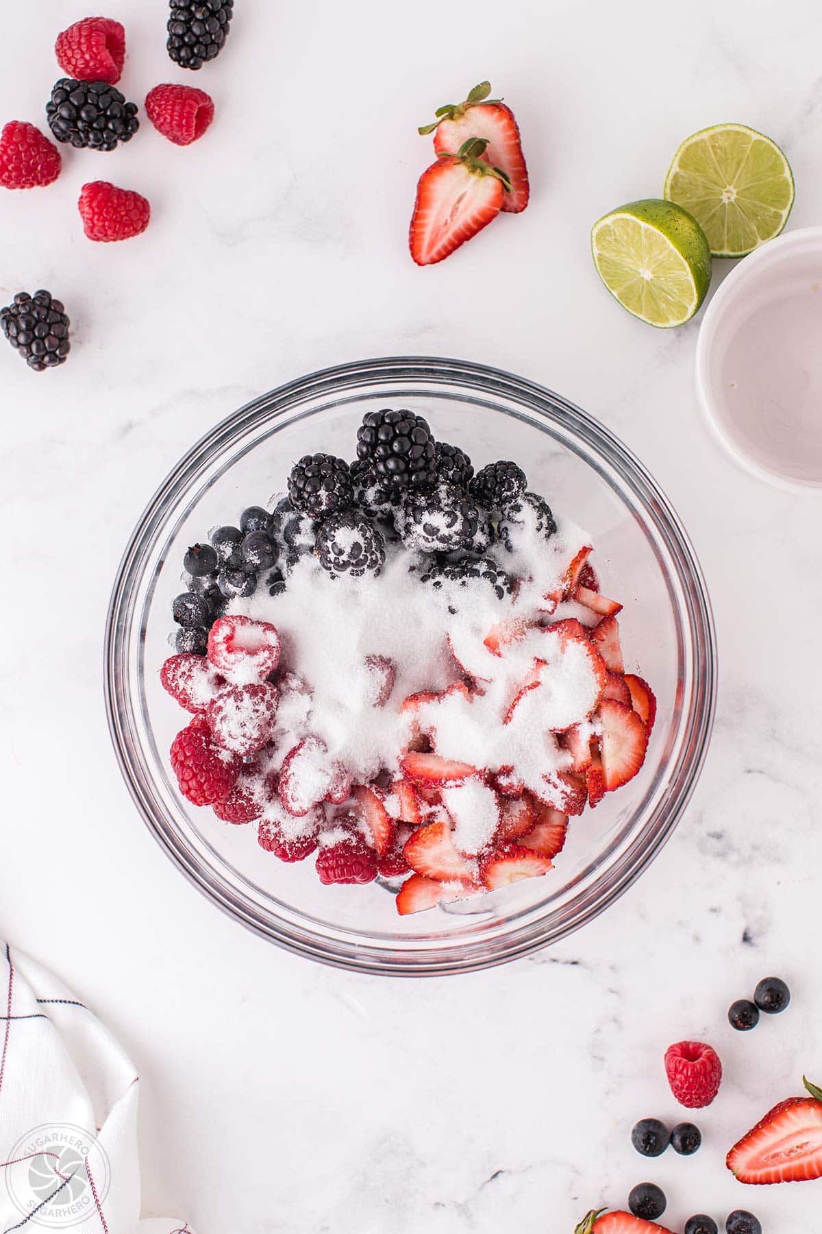 A bowl of mixed berries covered with sugar.