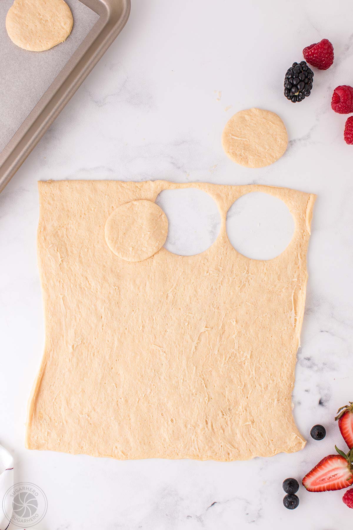 Crescent dough with circles cut out of it.
