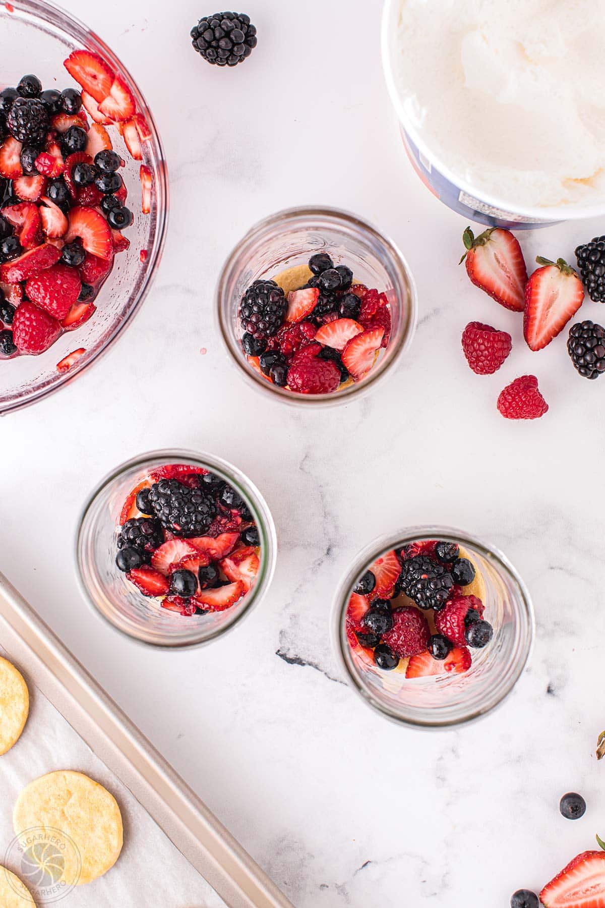 Mixed berries on top of crescent rolls in mason jars.