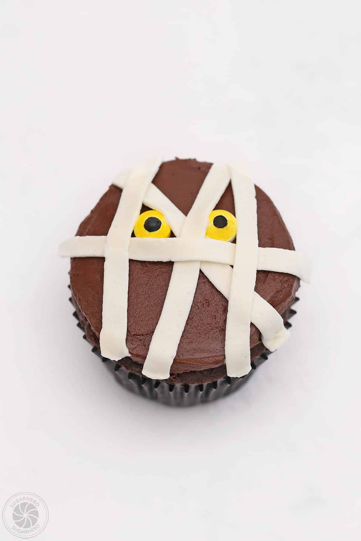 Mummy Cupcake with a few white lines of frosting criss crossing on top.