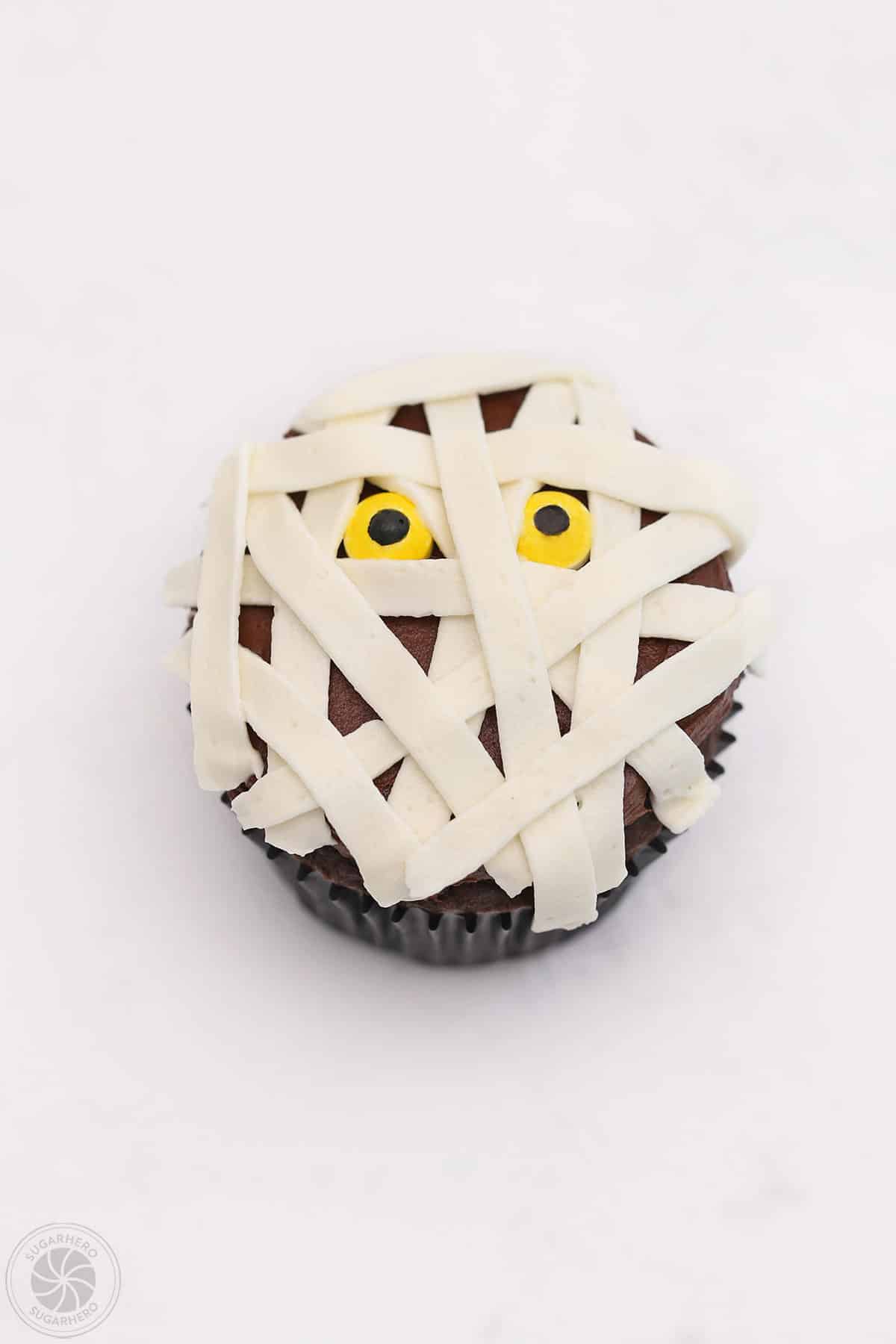 Mummy Cupcake with criss crossing lines of white frosting on top.