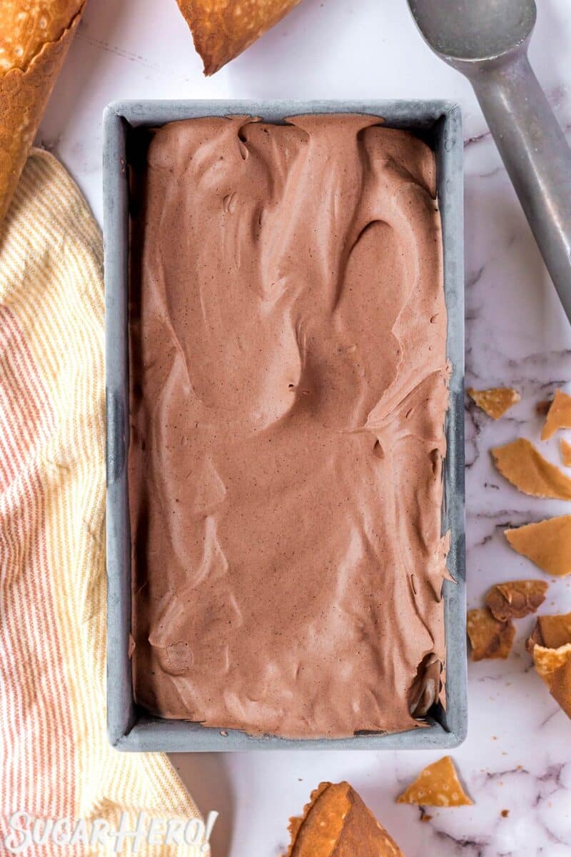 Frozen No-Churn Chocolate Ice Cream in a silver container with ice cream scoop in the background.