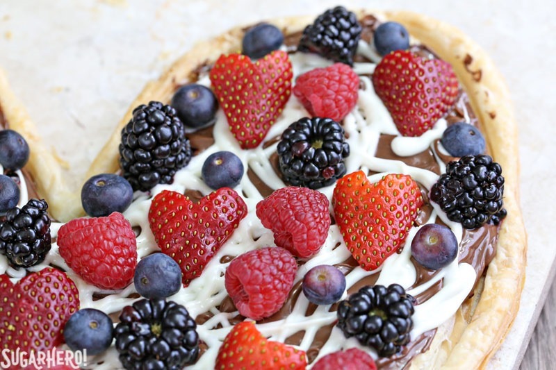 Nutella Puff Pastry Pizza is easy and gourmet. You&rsquo;ll love the combination of buttery puff pastry, Nutella, white chocolate, and juicy fresh berries! | From SugarHero.com