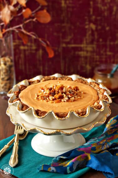 Butterscotch Mousse Pie in a scalloped white and gold pie plate on a teal napkin.