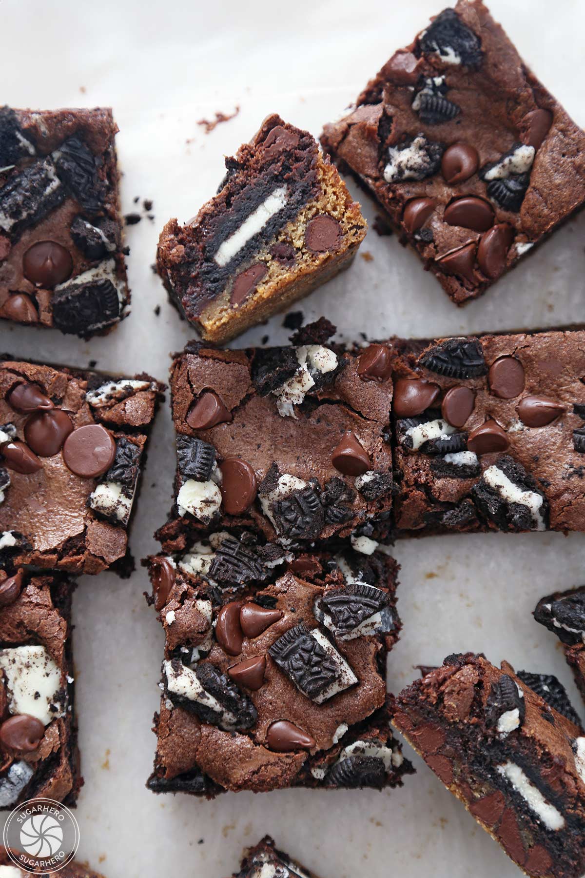 Overhead shot of a group of Oreo Brookies on white parchment, with one turned on its side.
