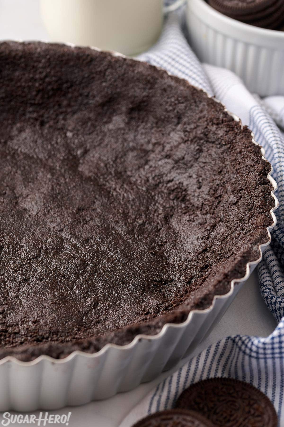 Half of an Oreo Pie Crust in a silver pie pan.