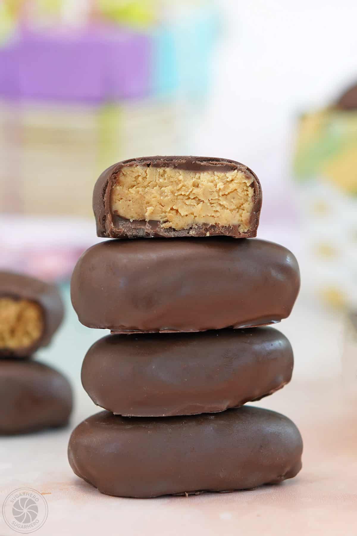 A stack of four peanut butter Easter eggs with the top one cut in half to show the center.