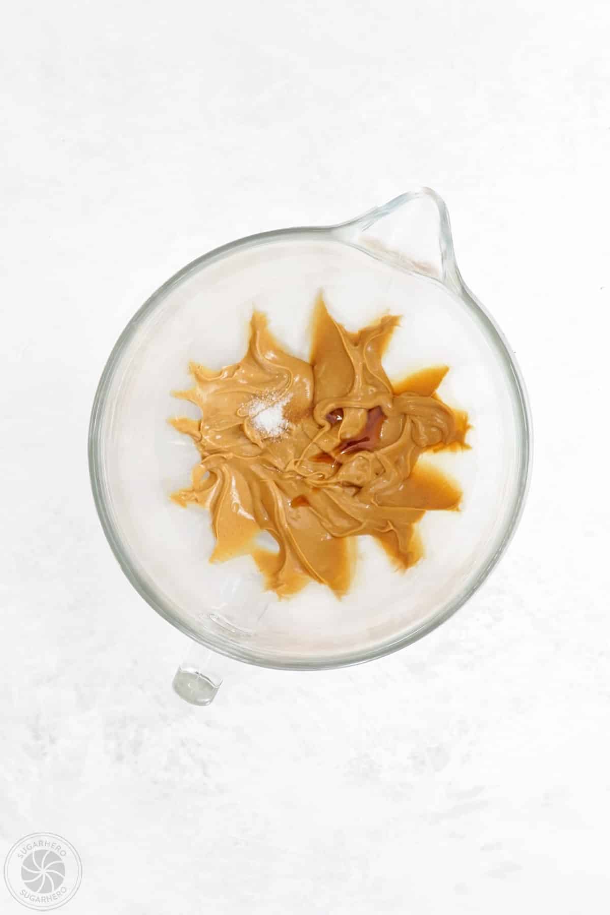 Salt and vanilla extract being added to a peanut butter mixture.