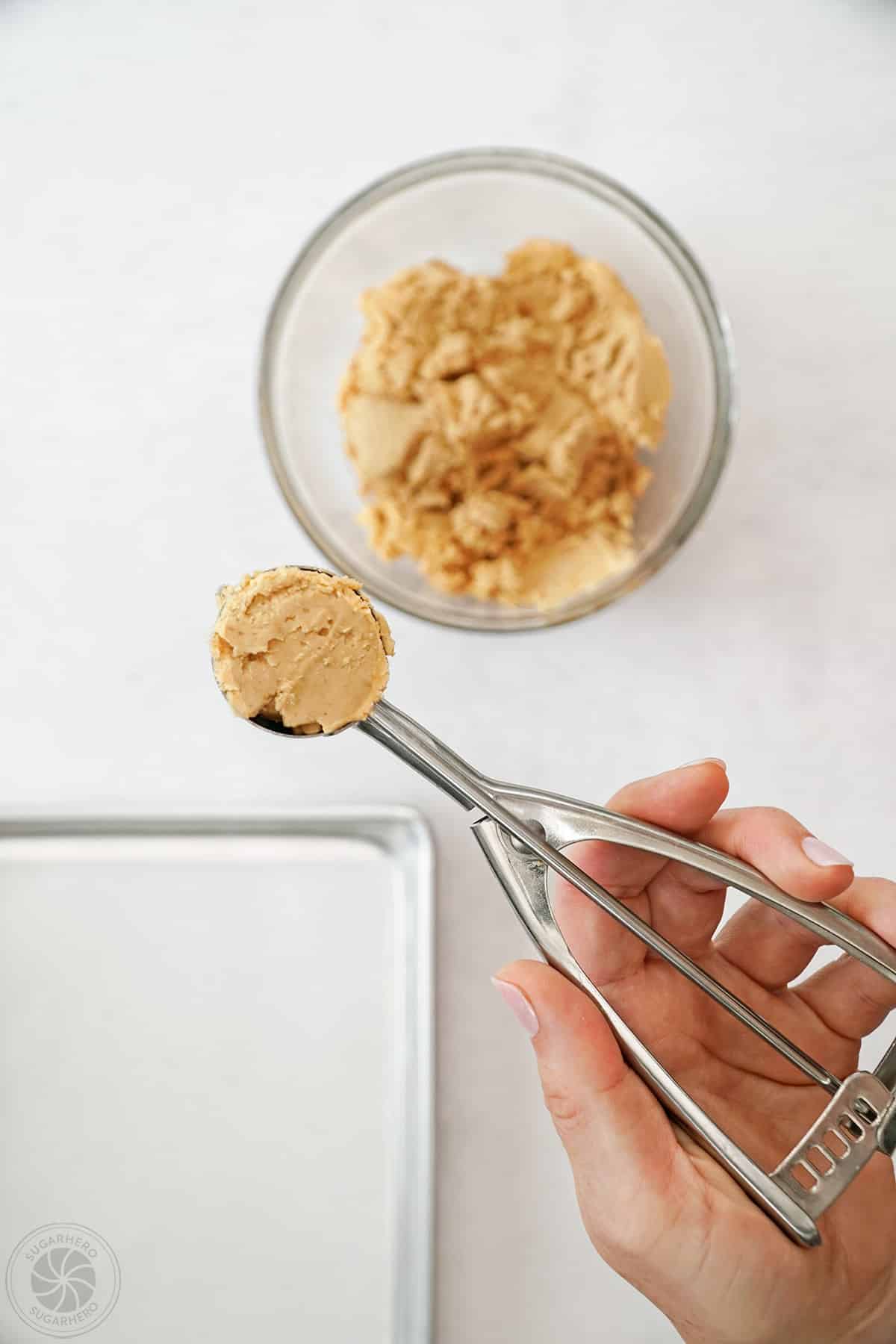 Hand showing a cookie scoop of peanut butter filling.