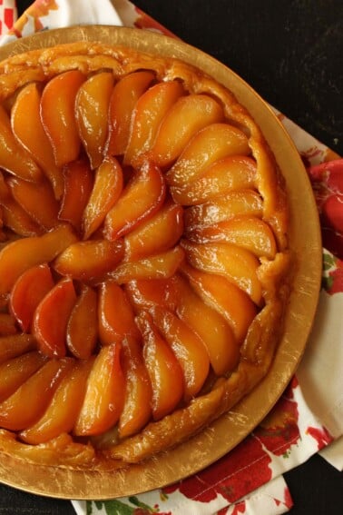 Close up of half a Pear Tarte Tatin on a golden plate.