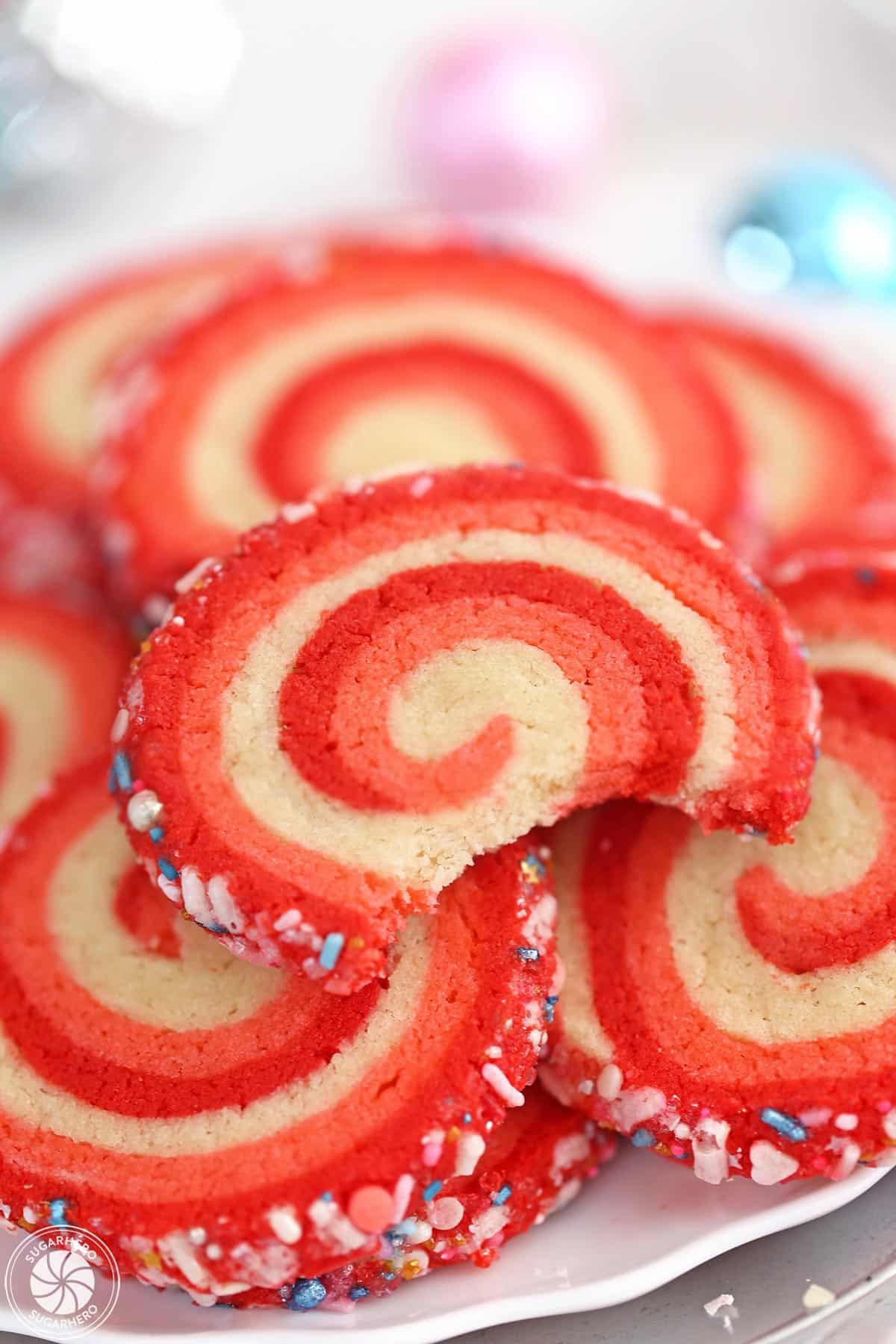 Peppermint Pinwheel Cookie on a plate of cookies with a bite taken out of it.