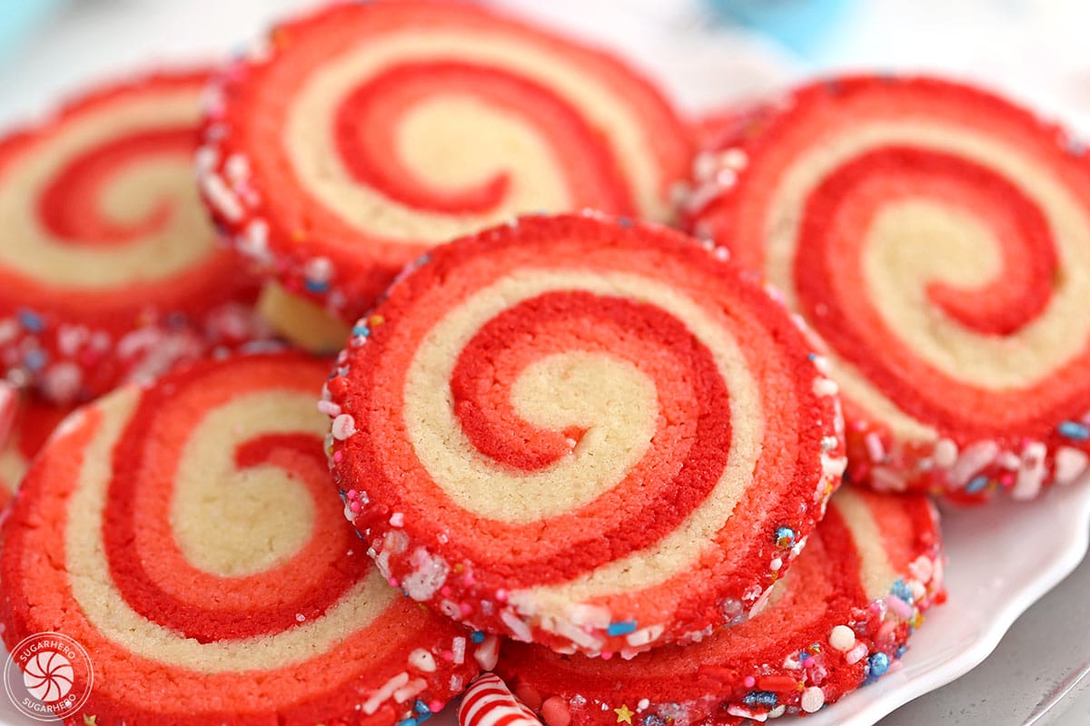 Close-up of baked Peppermint Pinwheel Cookies on white plate.