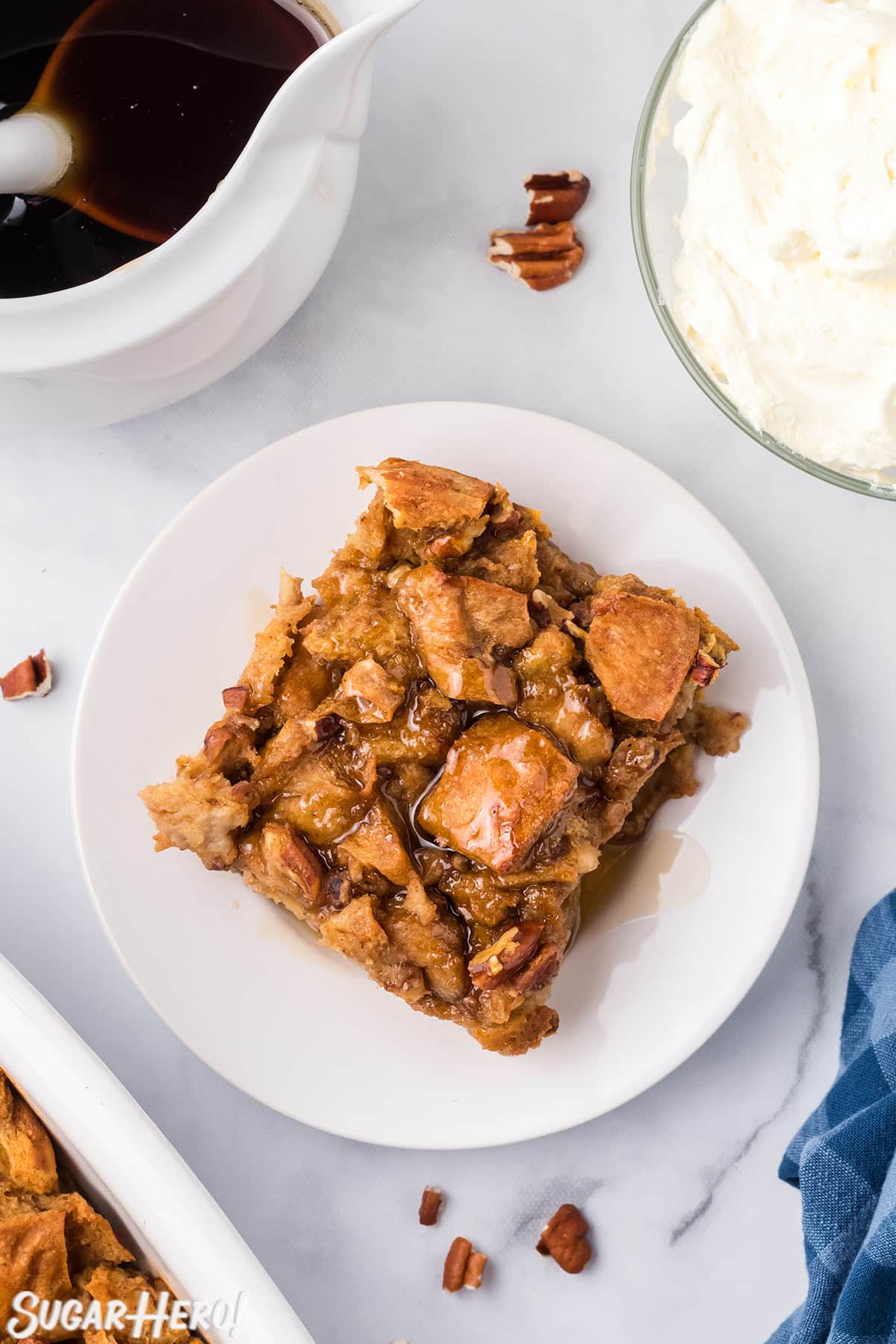 Slice of Pumpkin Bread Pudding on a white plate, drizzled with cinnamon syrup.