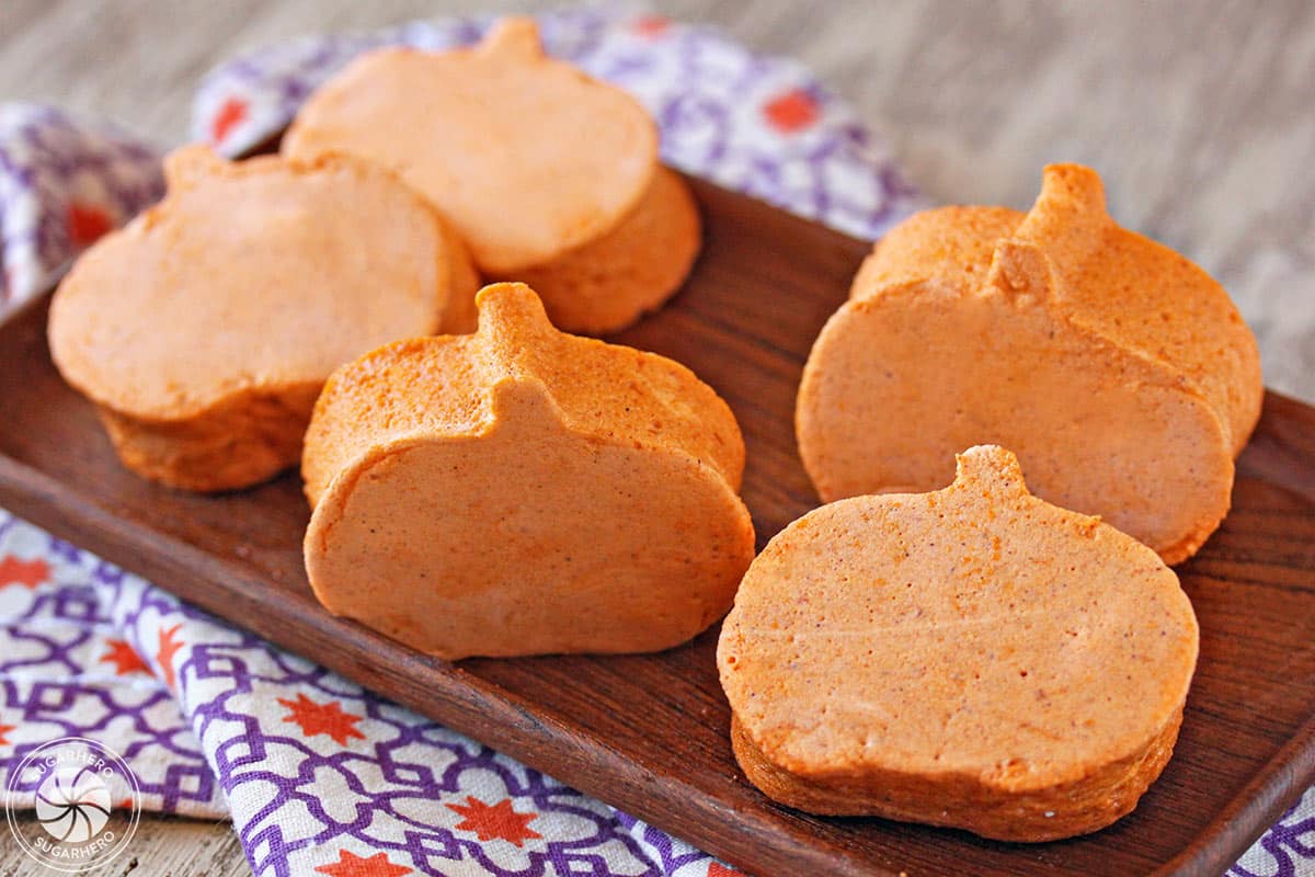 Pumpkin Marshmallows cut into the shape of pumpkins, on a wooden platter.