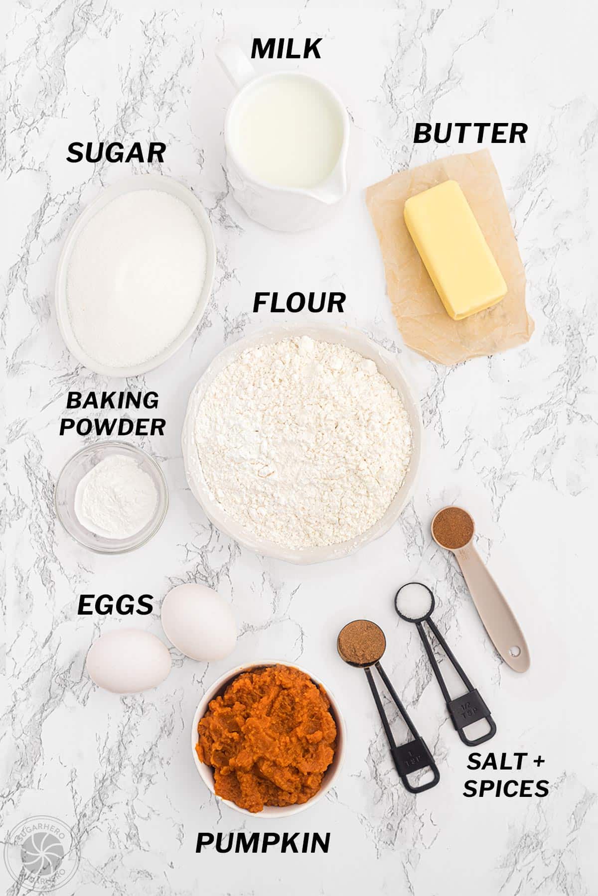 Photo of various ingredients for pumpkin spice cupcakes measured out on a marble counter.