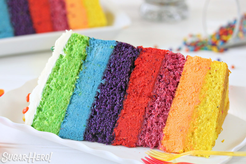 Slice of Rainbow Mousse Cake on a fluted white plate.