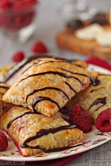A plate of Raspberry Brie and Chocolate Puff Pastries drizzled with chocolate.