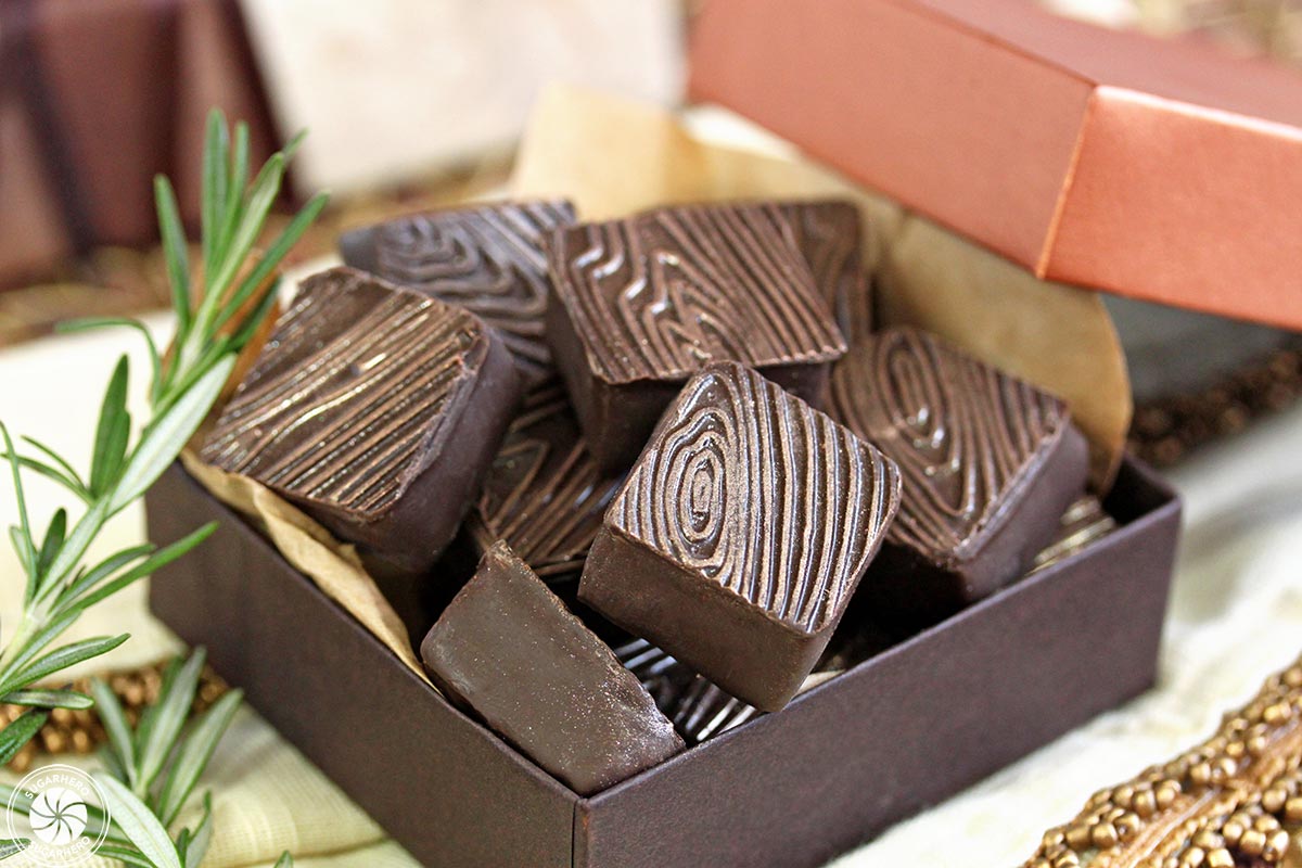 Rosemary Raspberry Truffles - close-up of square rosemary raspberry truffles with a gold-flecked wood grain pattern | From SugarHero.com