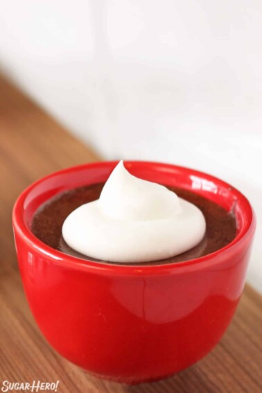 Salted Caramel Chocolate Mousse in a red bowl with a dollop of whipped cream.