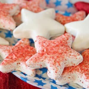 Star-shaped cookies dipped in white chocolate, some dusted with freeze-dried strawberry powder.