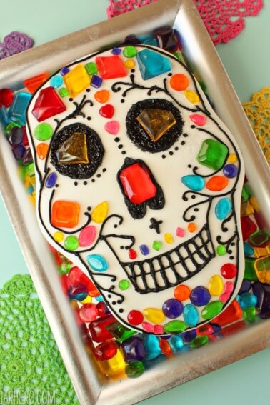 Chocolate Skull Cake on a silver platter surrounded by candy jewels.