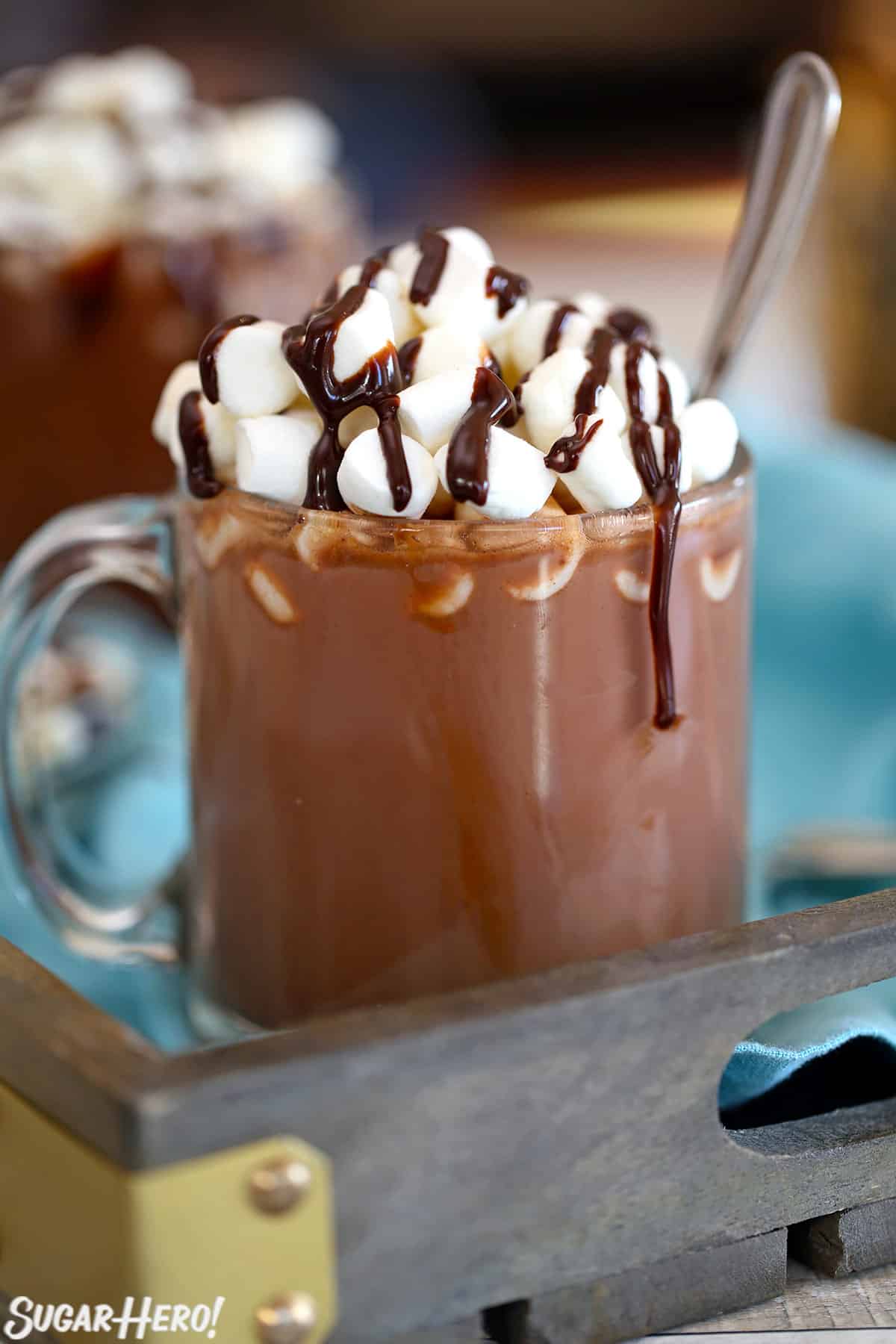 Slow Cooker Hot Chocolate in a glass mug with mini marshmallows and a chocolate drizzle