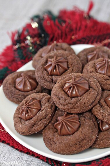 Soft chocolate gingerbread cookies on a white plate with a red and green napkin in the background.