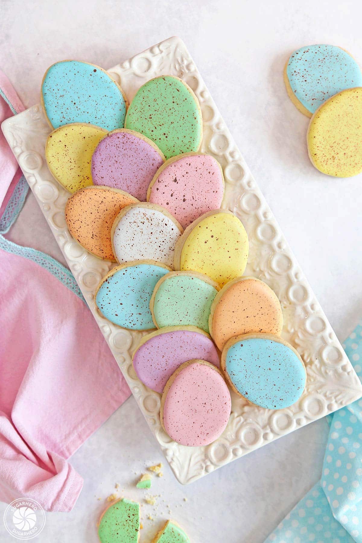 Overhead shot of pastel Speckled Easter Egg Sugar Cookies arranged on a rectangular white tray.