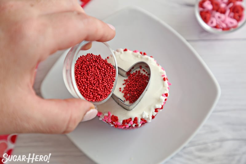 Filling the inside of a cookie cutter with small round sprinkles