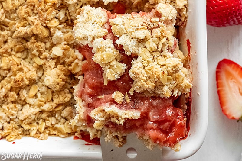 Spatula removing a serving of Strawberry Crisp from the baking pan.
