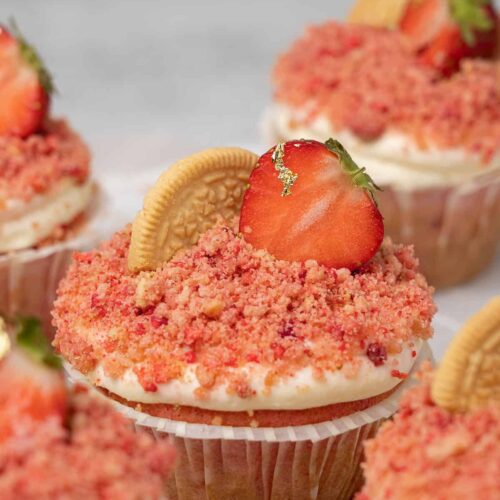 Close up of Strawberry Crunch Cupcake decorated with a vanilla cookie and strawberry.