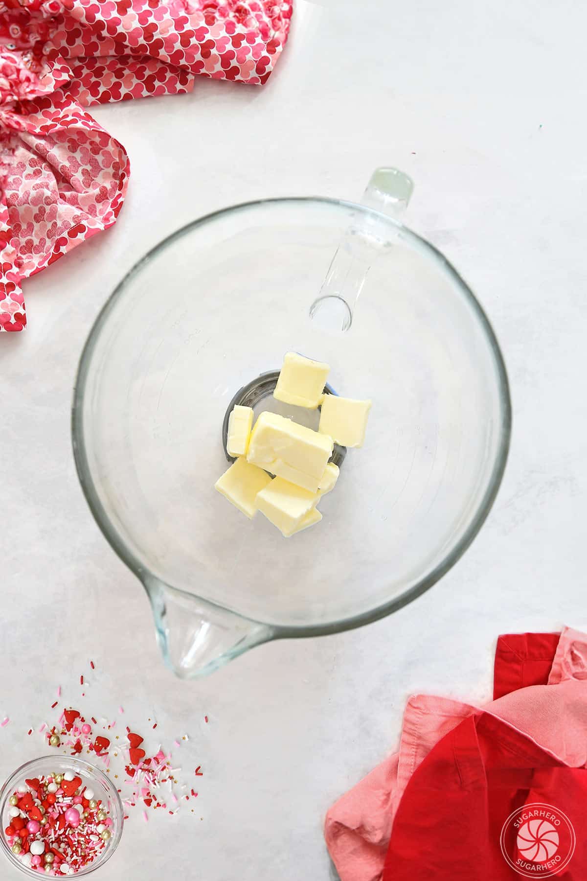 Butter cubes in a clear mixing bowl.