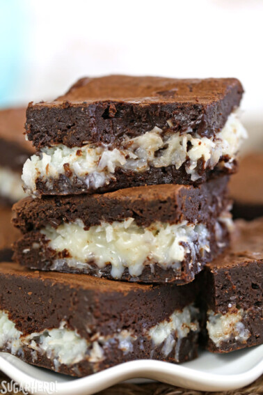 3 cut Coconut Brownie squares on a white plate.