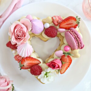 Close up of embellished trendy cream tart on a white plate.