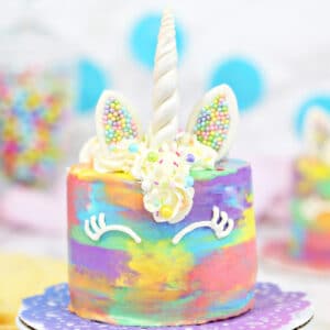 Close up of a unicorn cake on a colorful doilie.