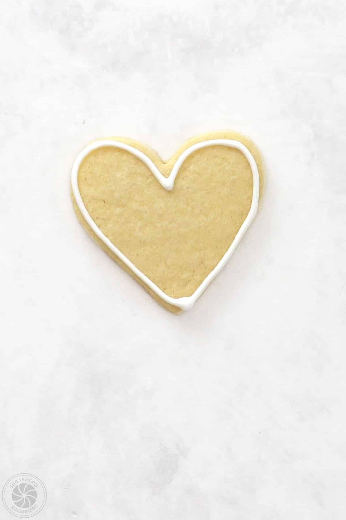 A Valentine's Day Sugar Cookie with a royal icing outline.