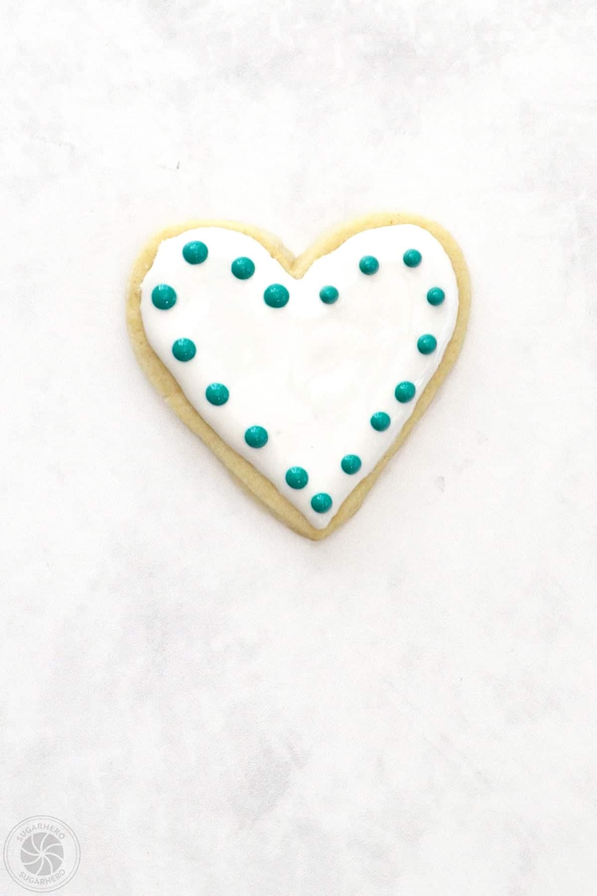 A Valentine's Day Sugar Cookie with an outline of small dots of royal icing.