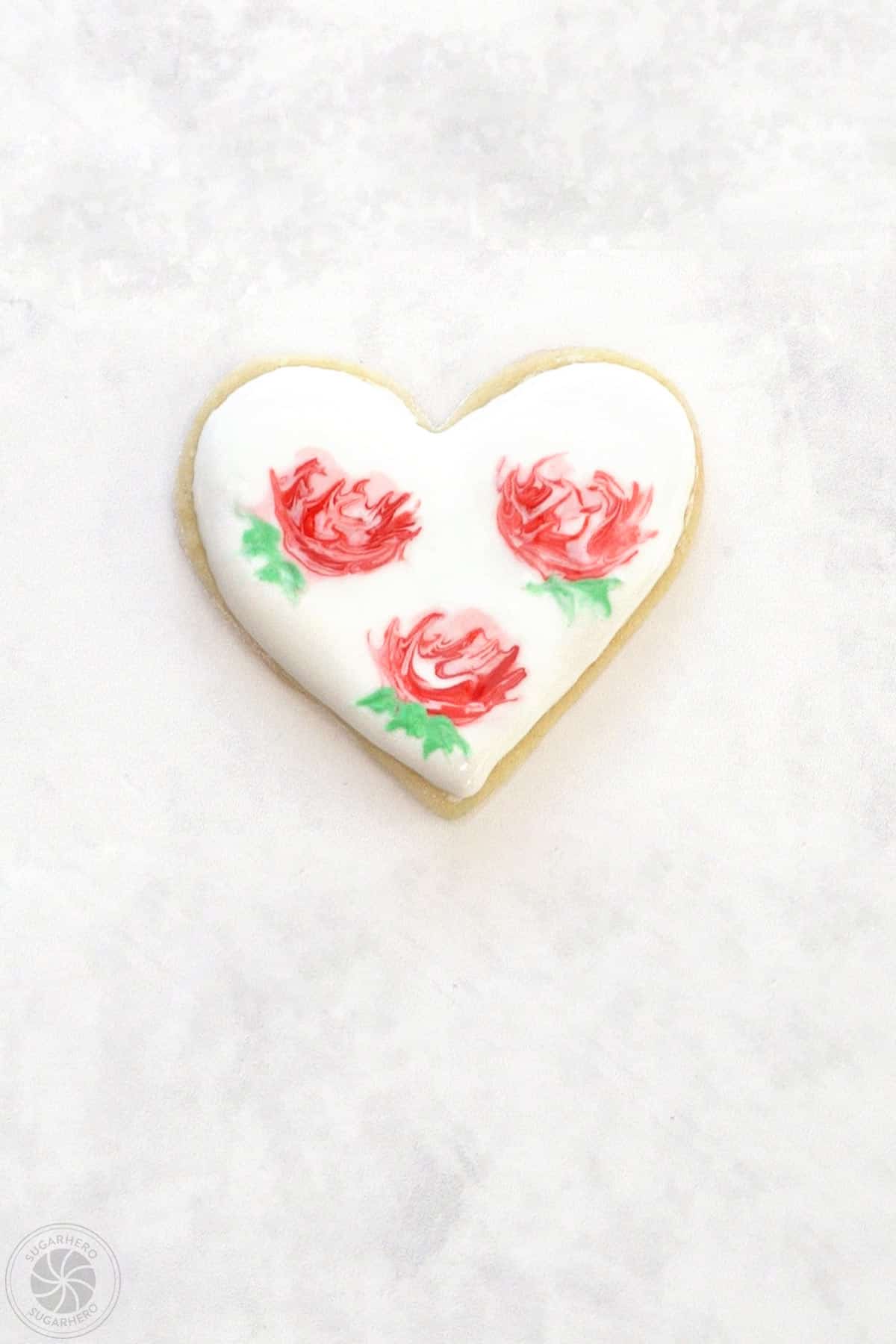 A Valentine's Day Sugar Cookie with 3 abstract roses on top.