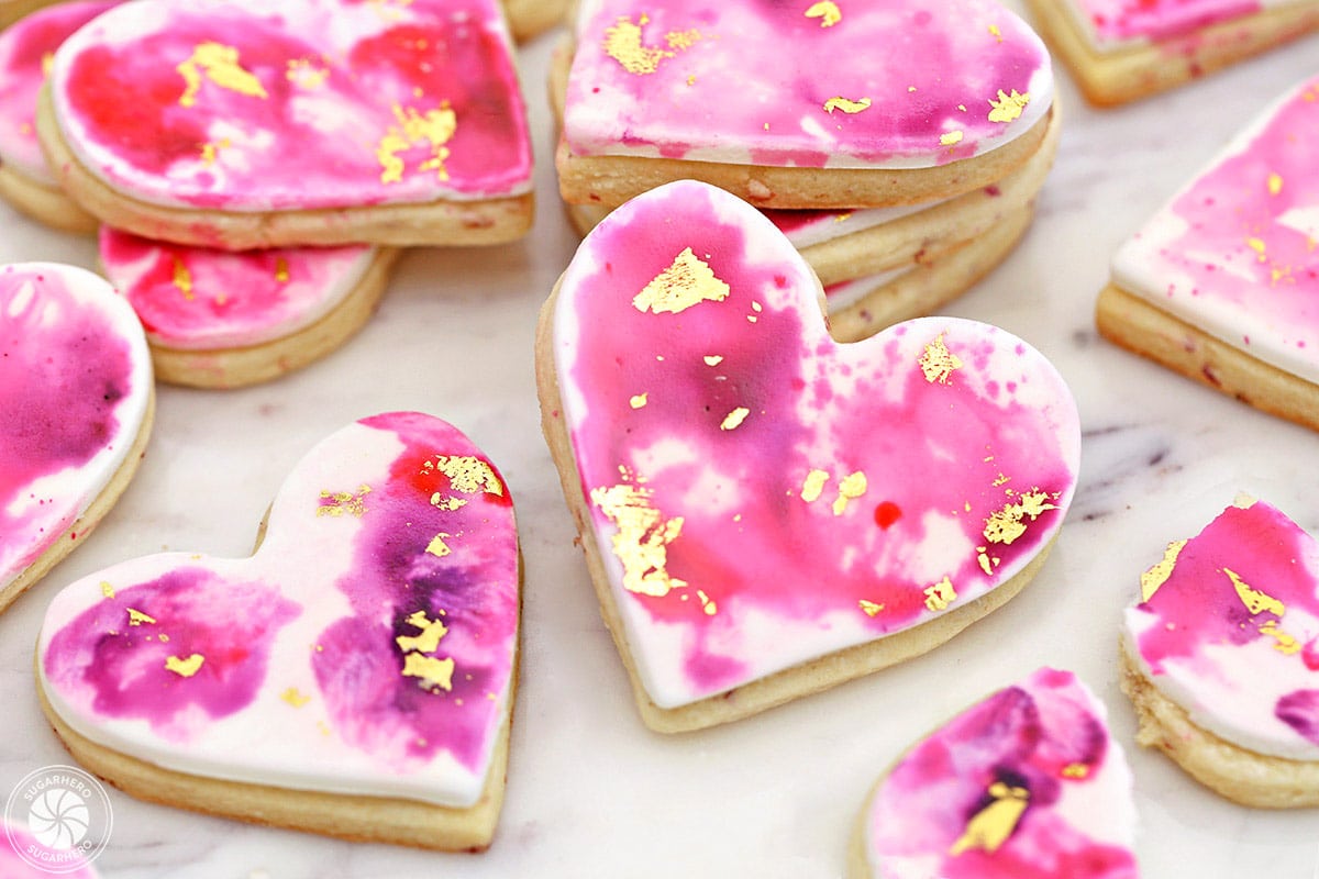 Several Watercolor Rose Sugar Cookies on a marble surface.