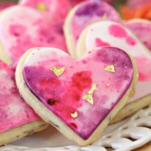 Close up of a Watercolor Rose Sugar Cookie on a white plate.