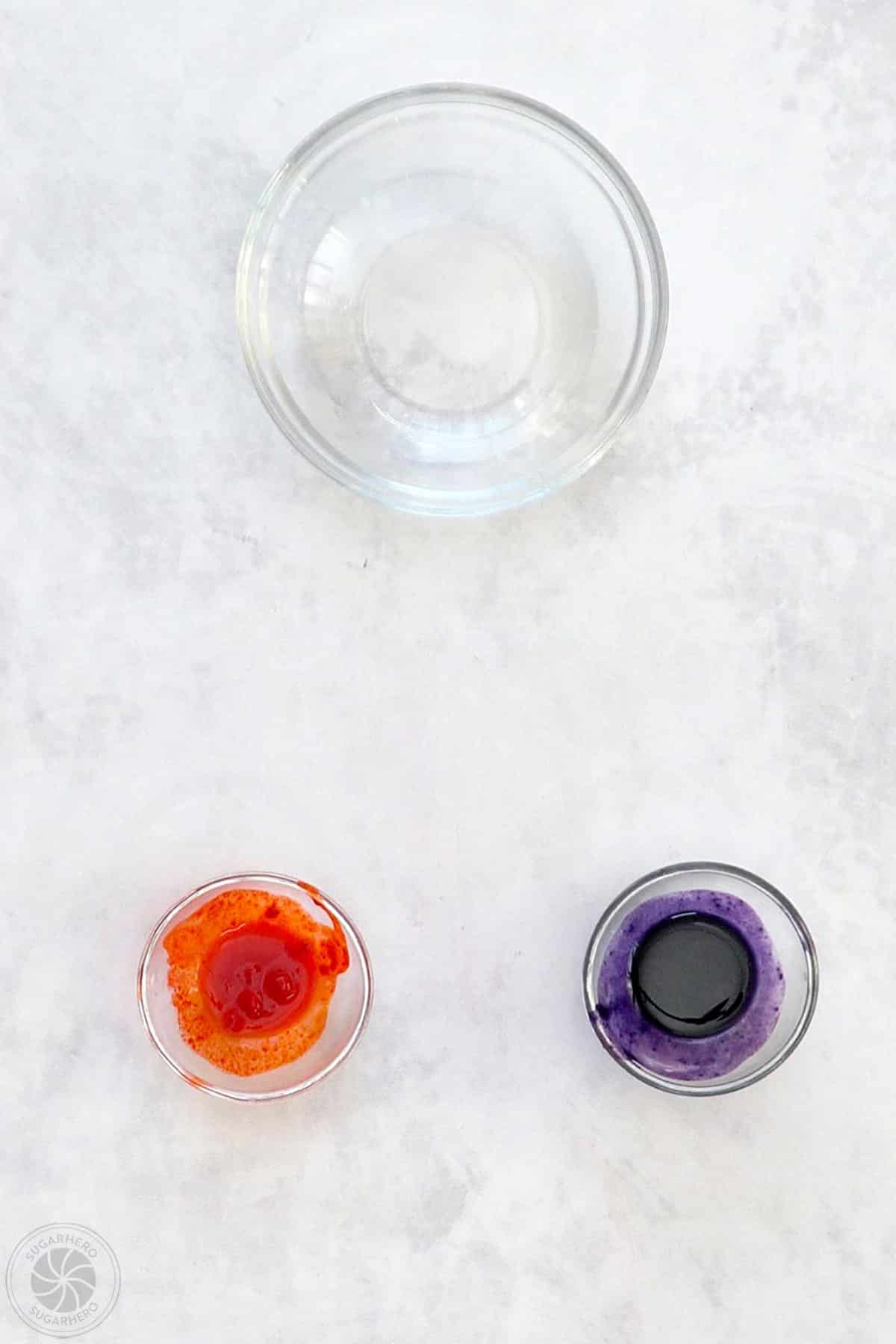 Two small bowls of thinned food coloring and a bowl of water.