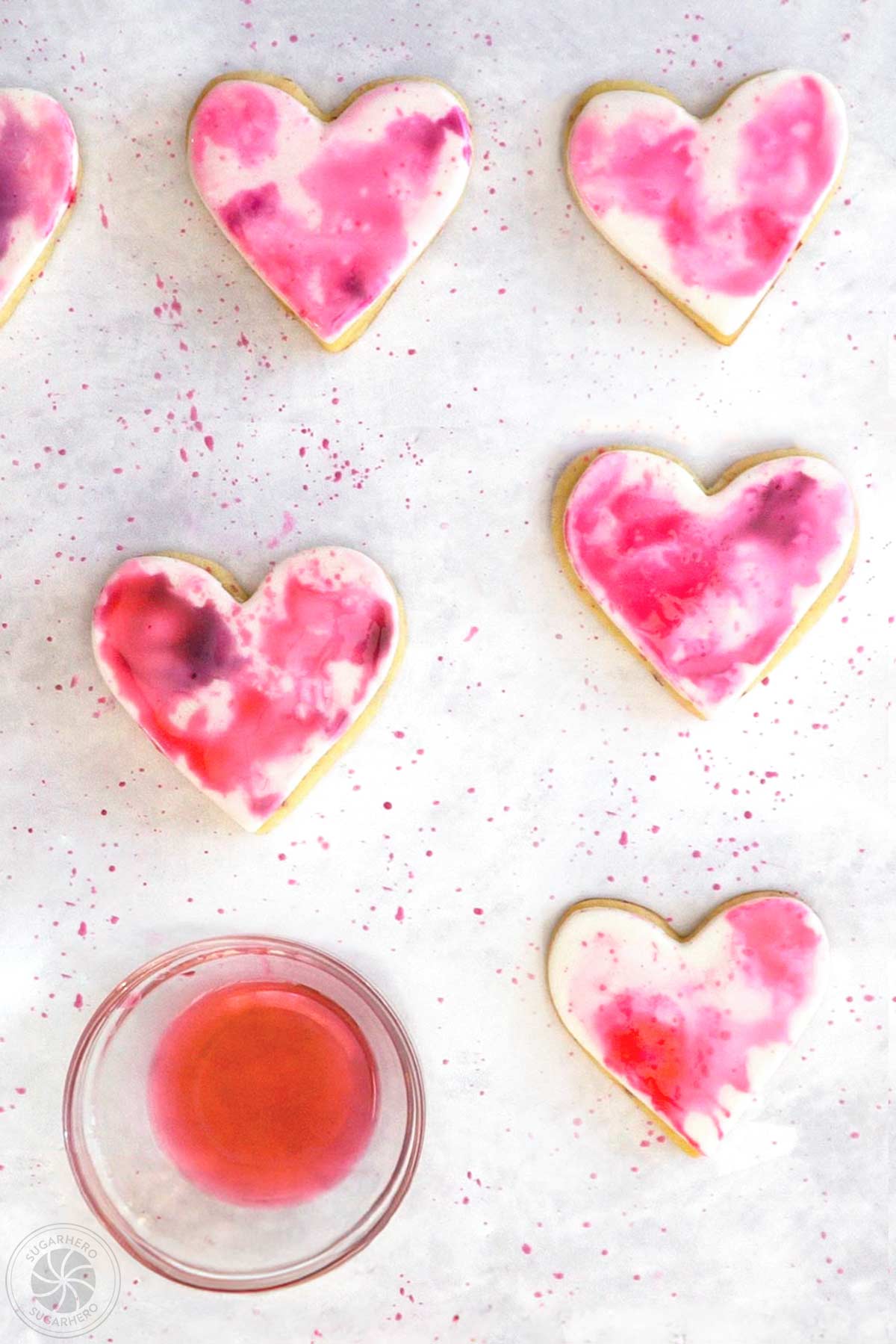 Watercolored sugar cookies after being speckled with food coloring.