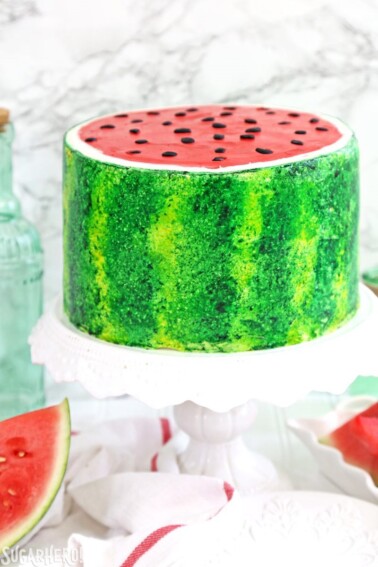 Watermelon Layer Cake on a white frilled cake platter.