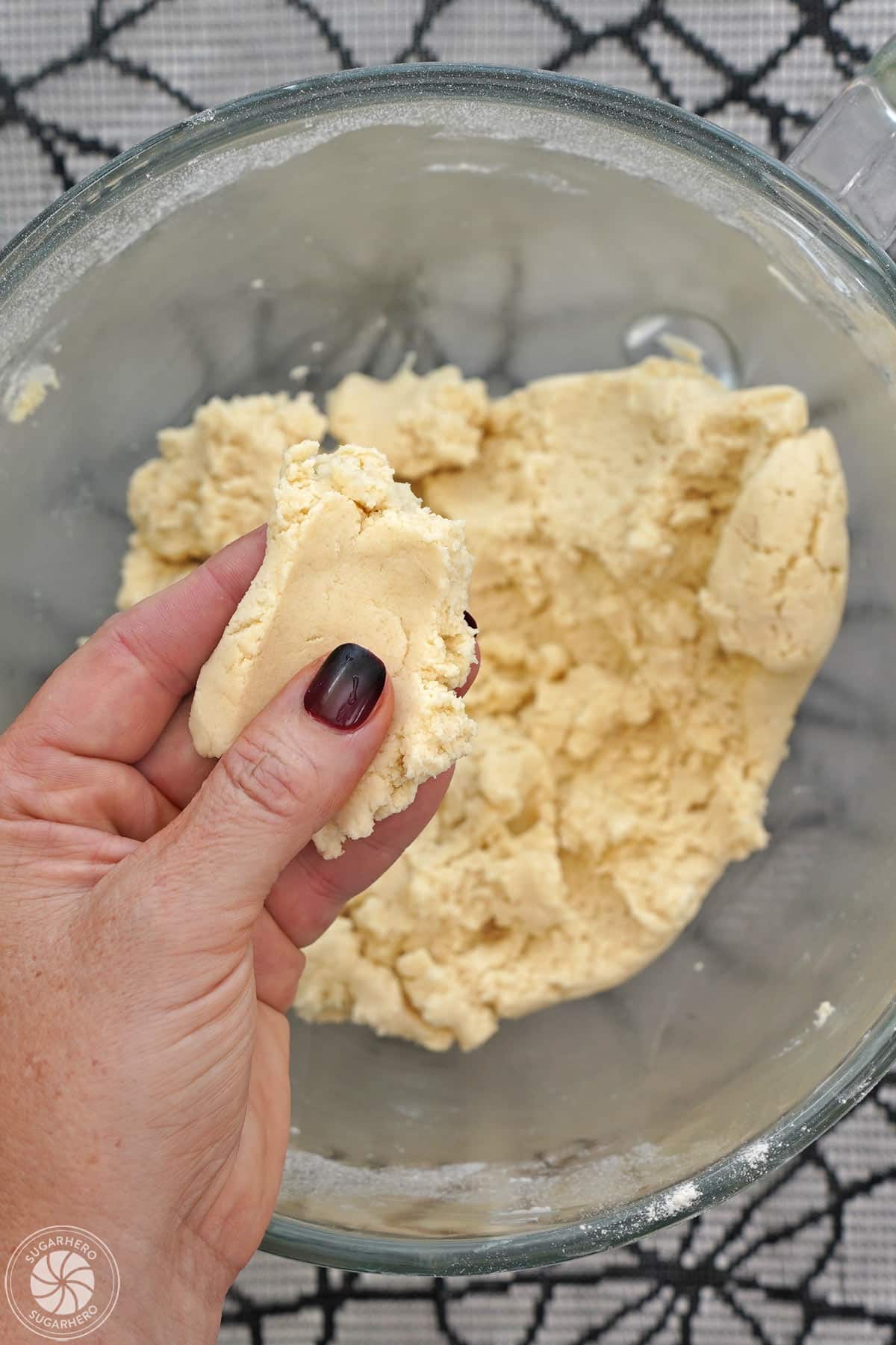Holding a handful of shortbread cookie dough to show the proper texture.