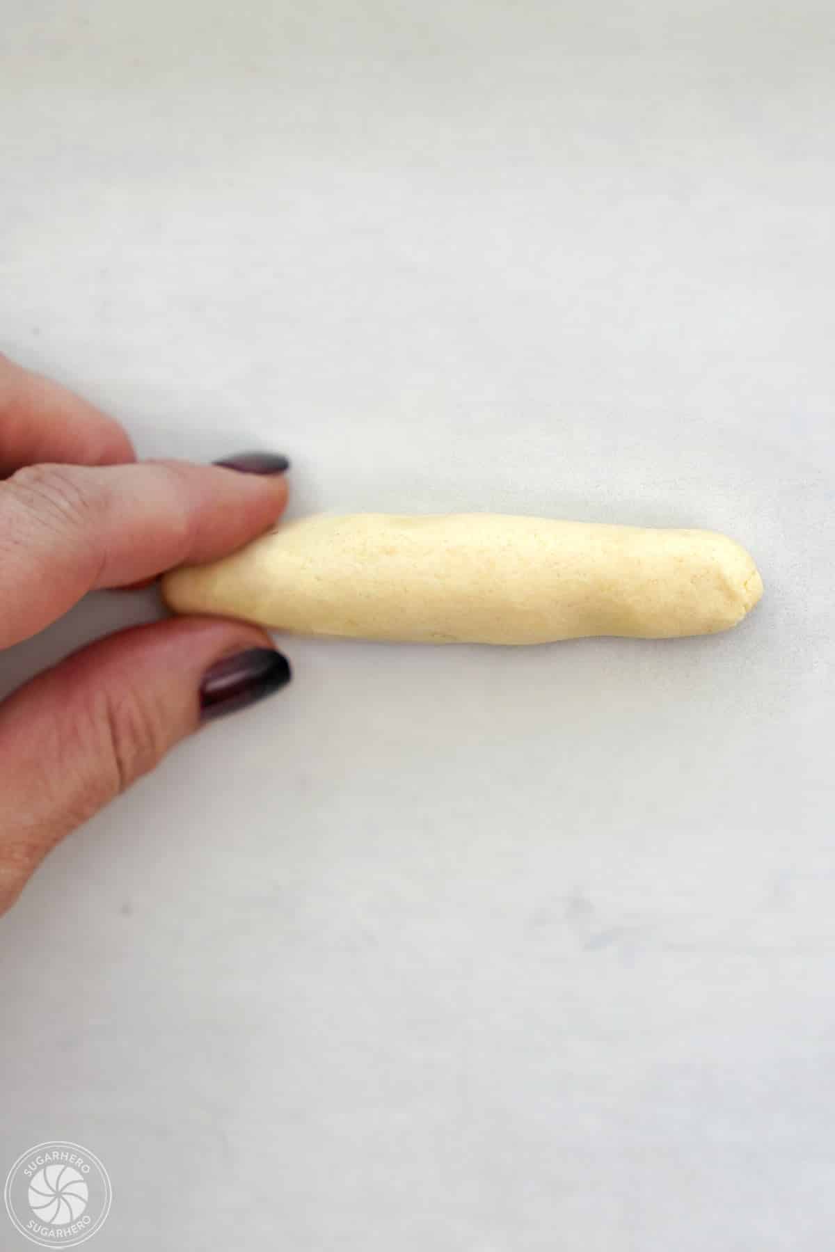 Shaping shortbread dough into a cylinder to make witch finger cookies.